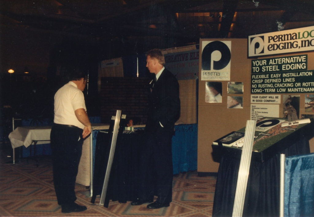 Dan Zwier, founder of Permaloc, stands next to his booth at a trade show.
